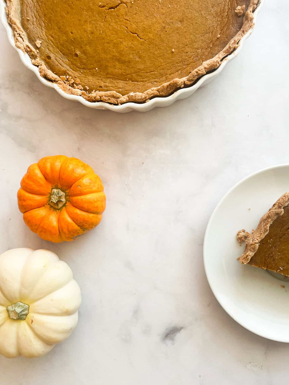 Mini pumpkins next to slices of pumpkin pie.