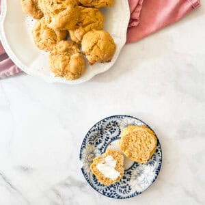 Butter on a sweet potato biscuit and a plate of biscuits.