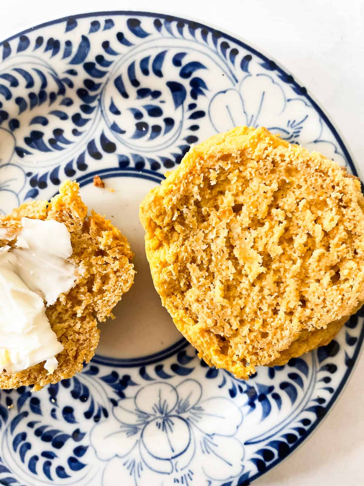 A sweet potato biscuit with butter on a plate.