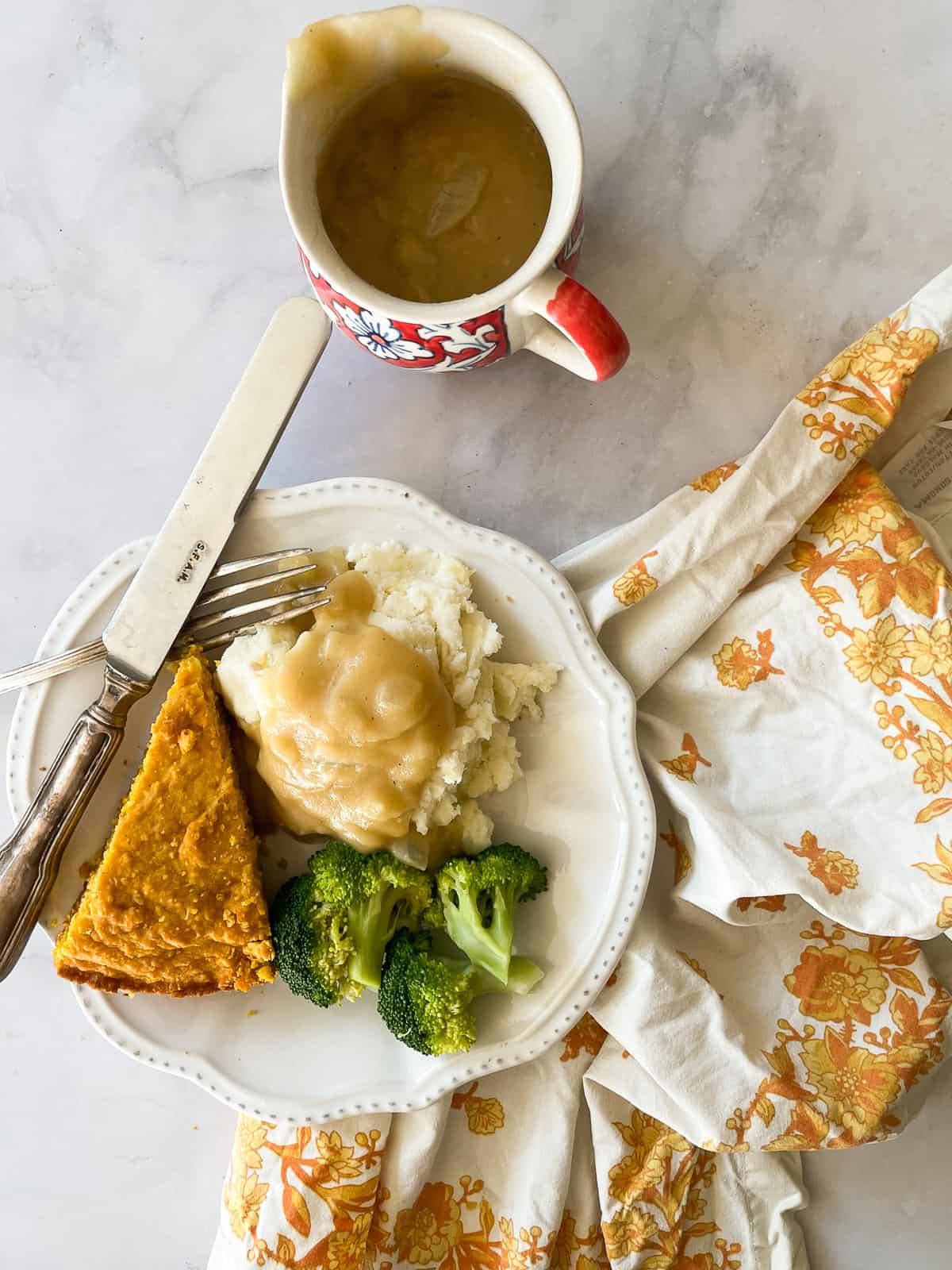 A plate of food including mashed potatoes with vegan gravy.