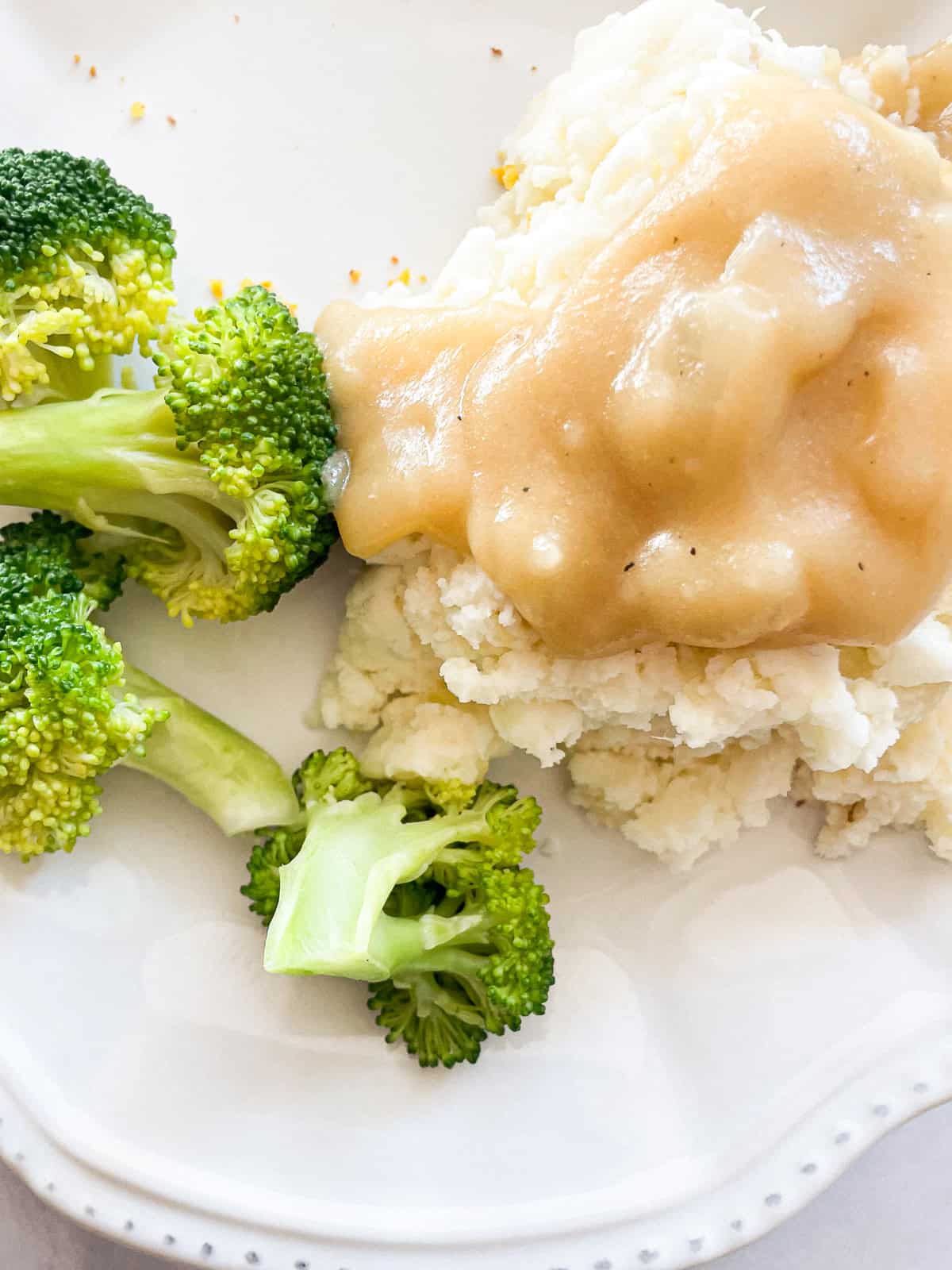 Vegetarian gravy on top of mashed potatoes and broccoli.