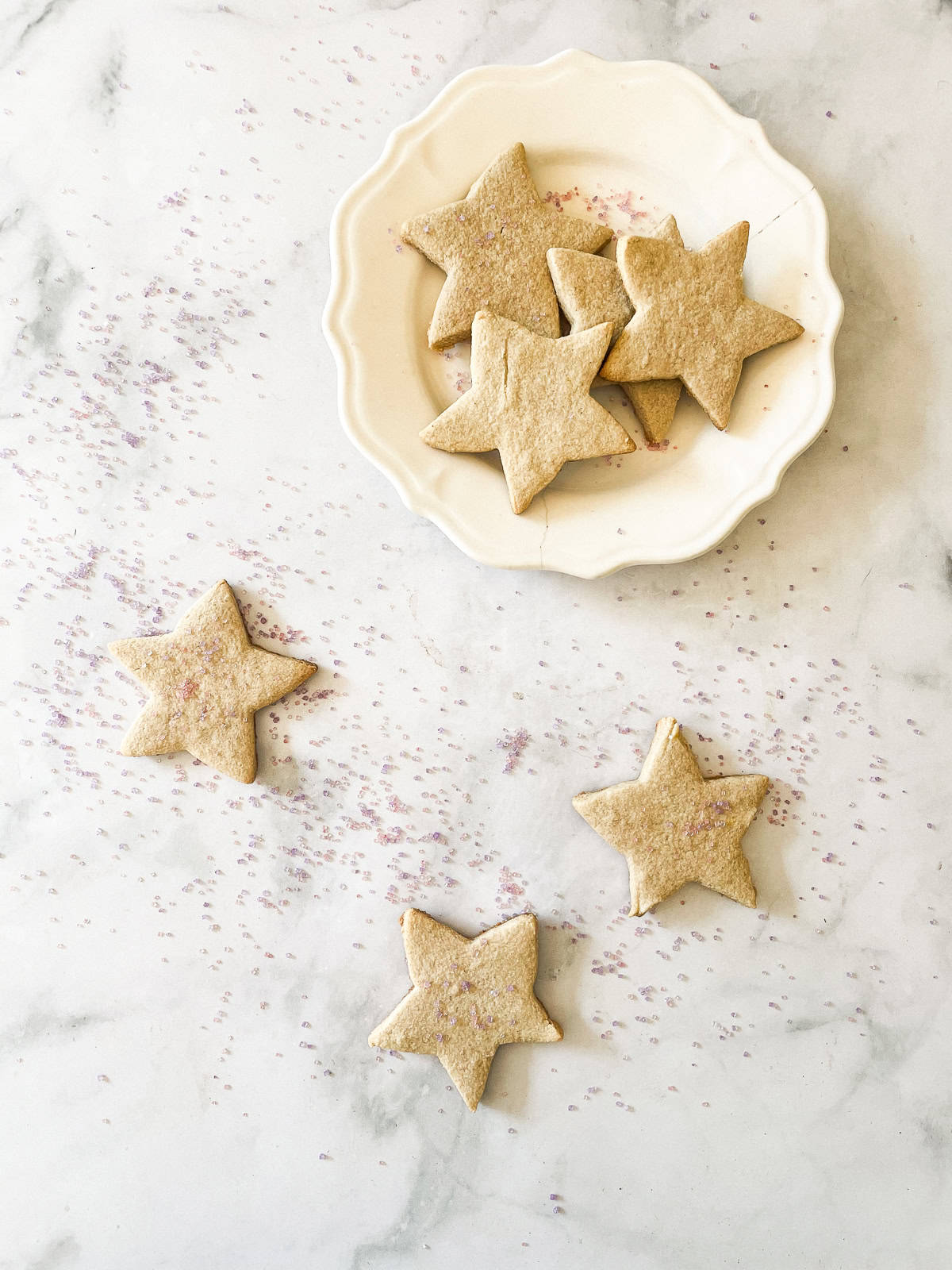 A plate of gluten free sugar cookies and cookies on a counter.