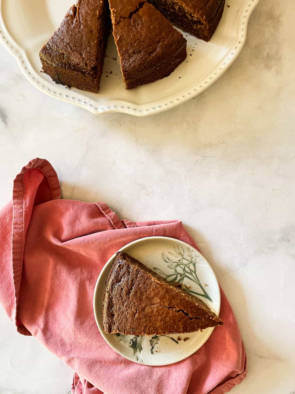 A red napkin and a plate with a slice of gluten-free gingerbread.