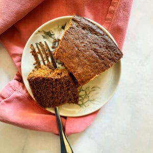 A piece of gluten-free gingerbread on a plate with a fork.