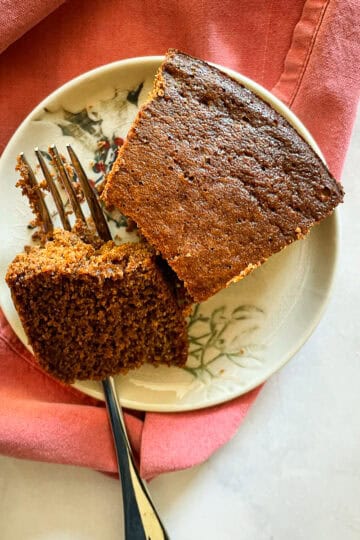 A piece of gluten-free gingerbread on a plate with a fork.