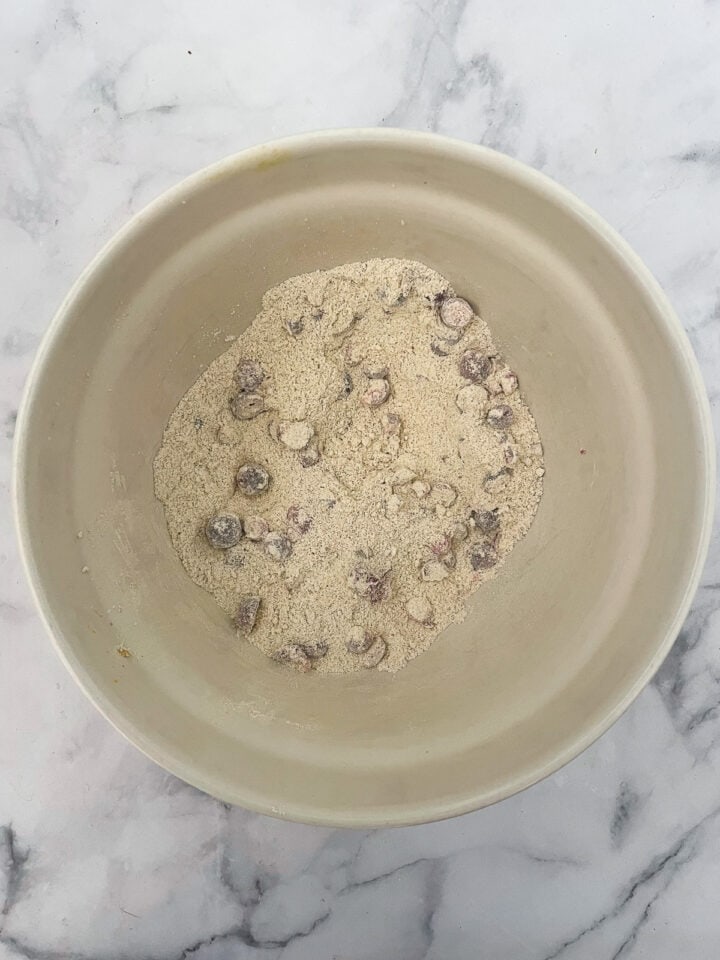 Cranberries mixed with a little flour in a bowl.