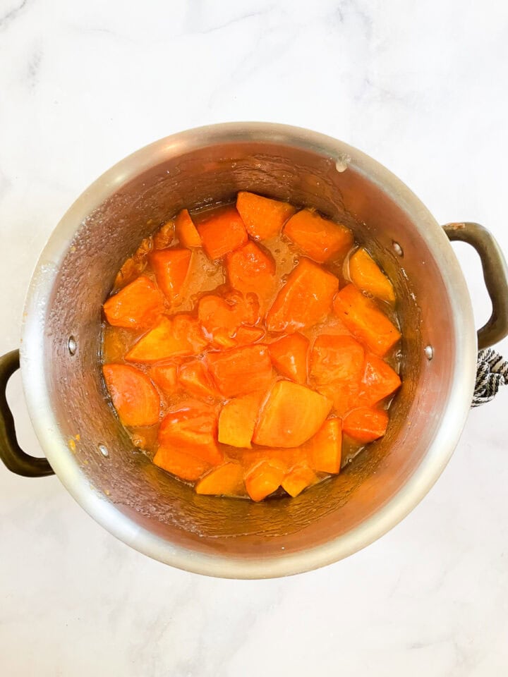 Persimmons and water and sugar in a pot.