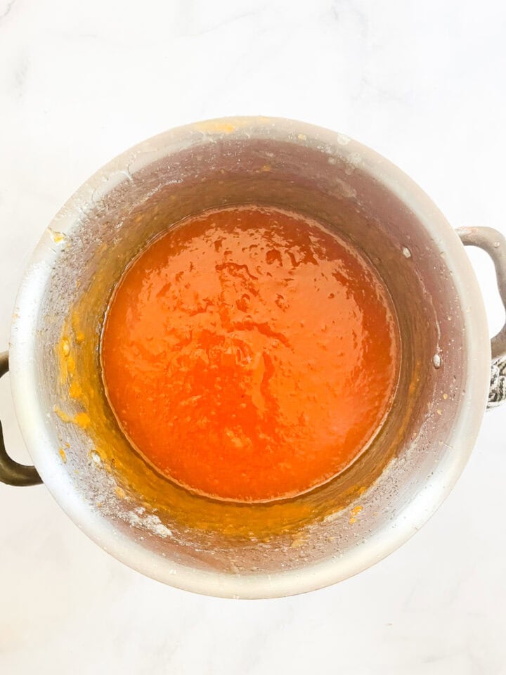 The persimmon jam mix pureed in a pot.