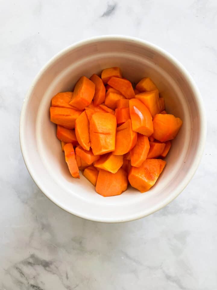 Cut up persimmons in a bowl.