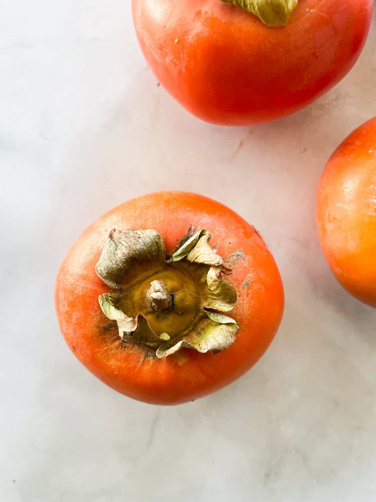 A persimmon on a counter.