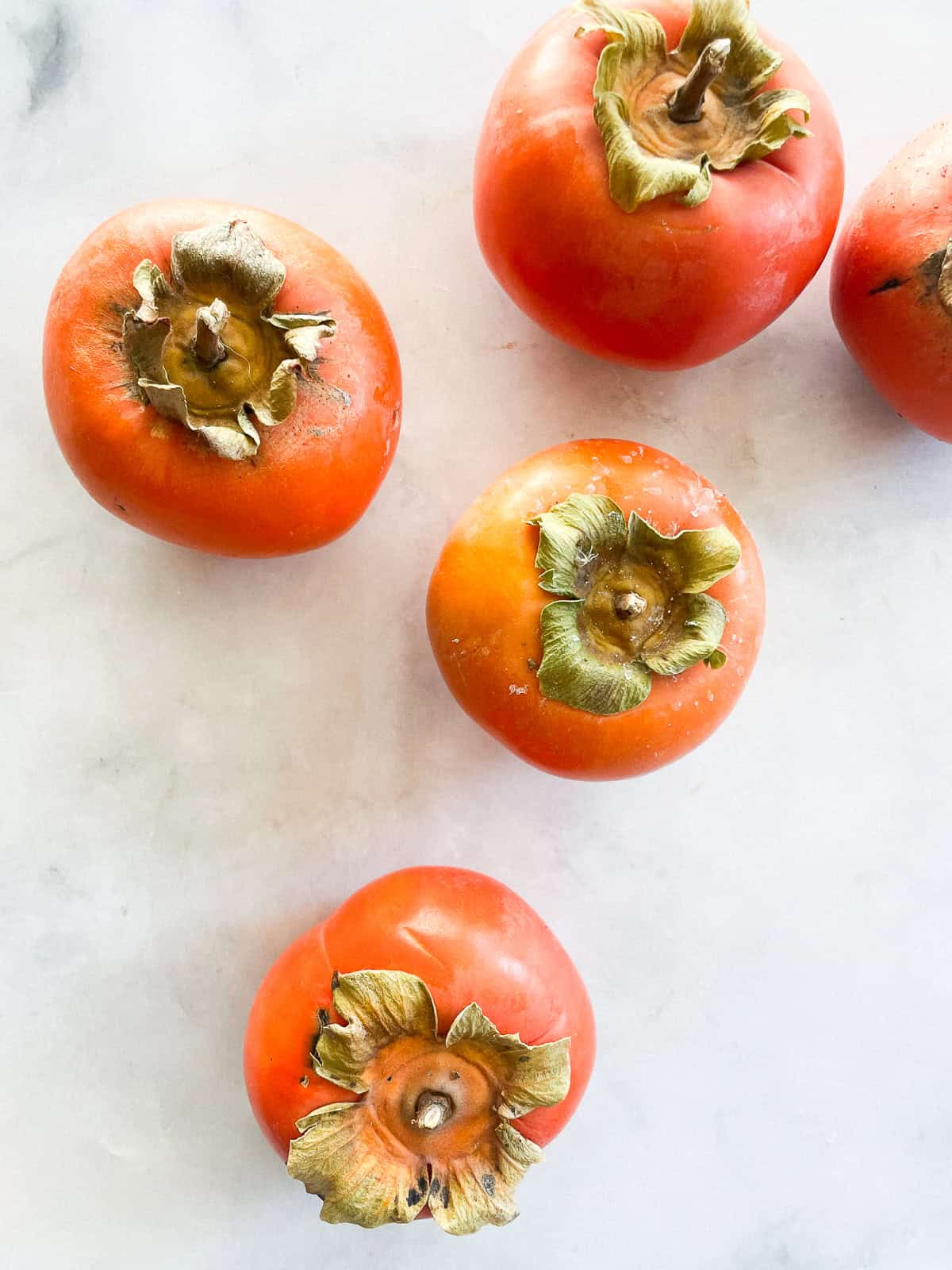 Fuyu persimmons on a counter.