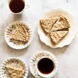 Plates of oat flour shortbread along with cups of tea.