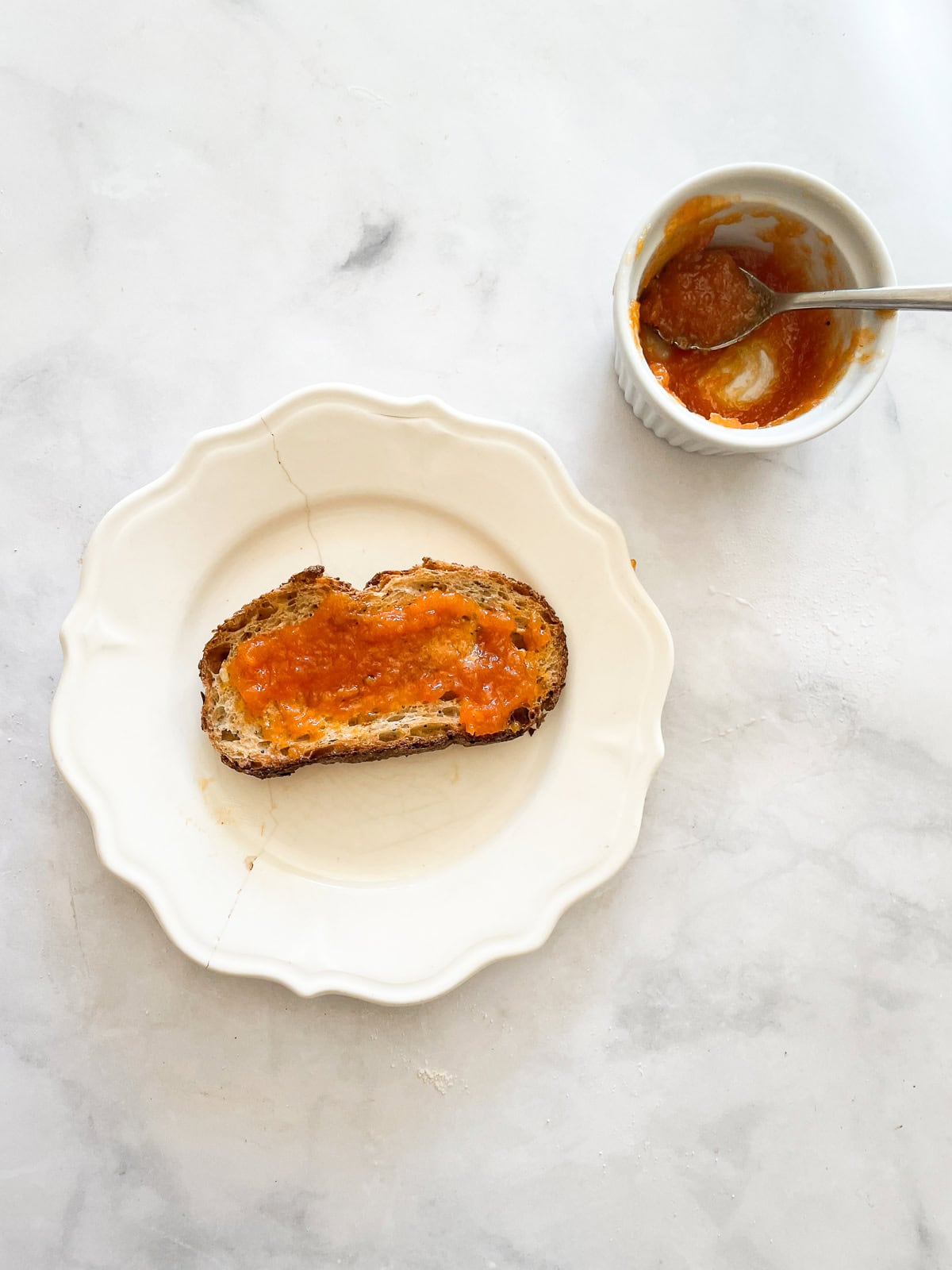 Toast with persimmon jam next to a dish of jam.