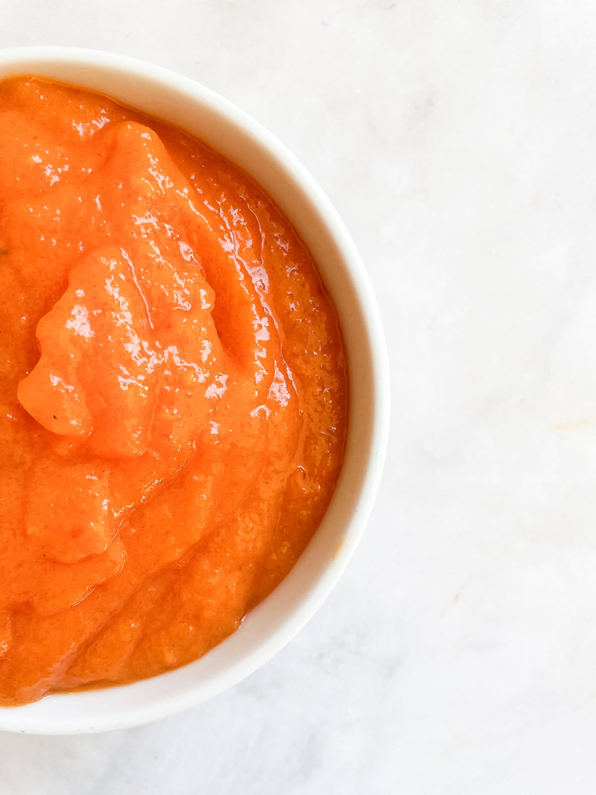 Half of a bowl of persimmon puree.