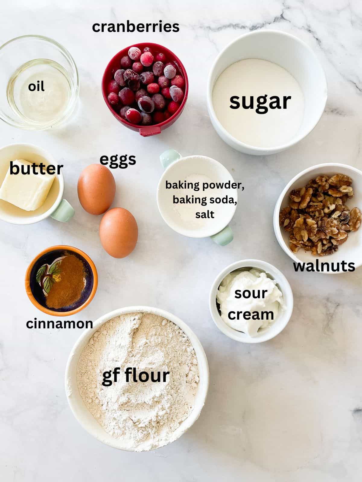 Ingredients for gluten free cranberry walnut bread are portioned and text-labeled.