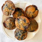 A white plate of banana blackberry muffins.