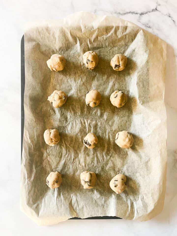 Cookie dough balls on a baking sheet.