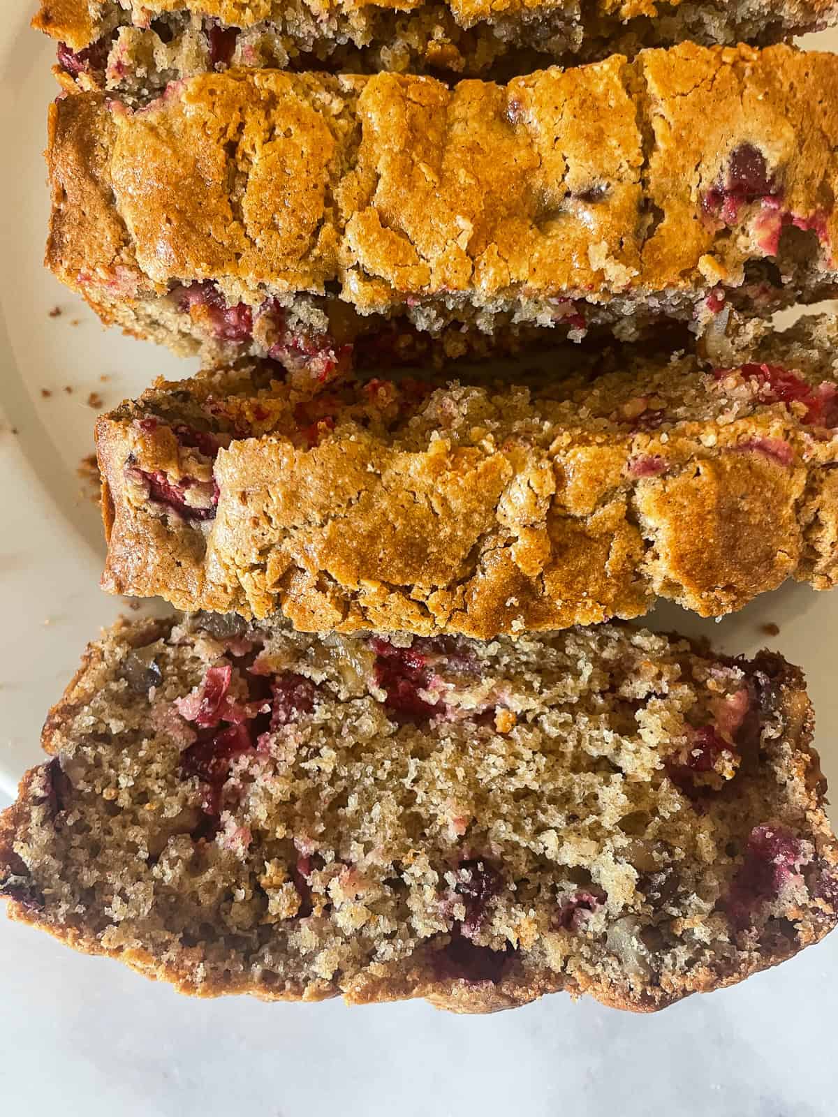 Thick slices of gluten free cranberry walnut bread on a plate.