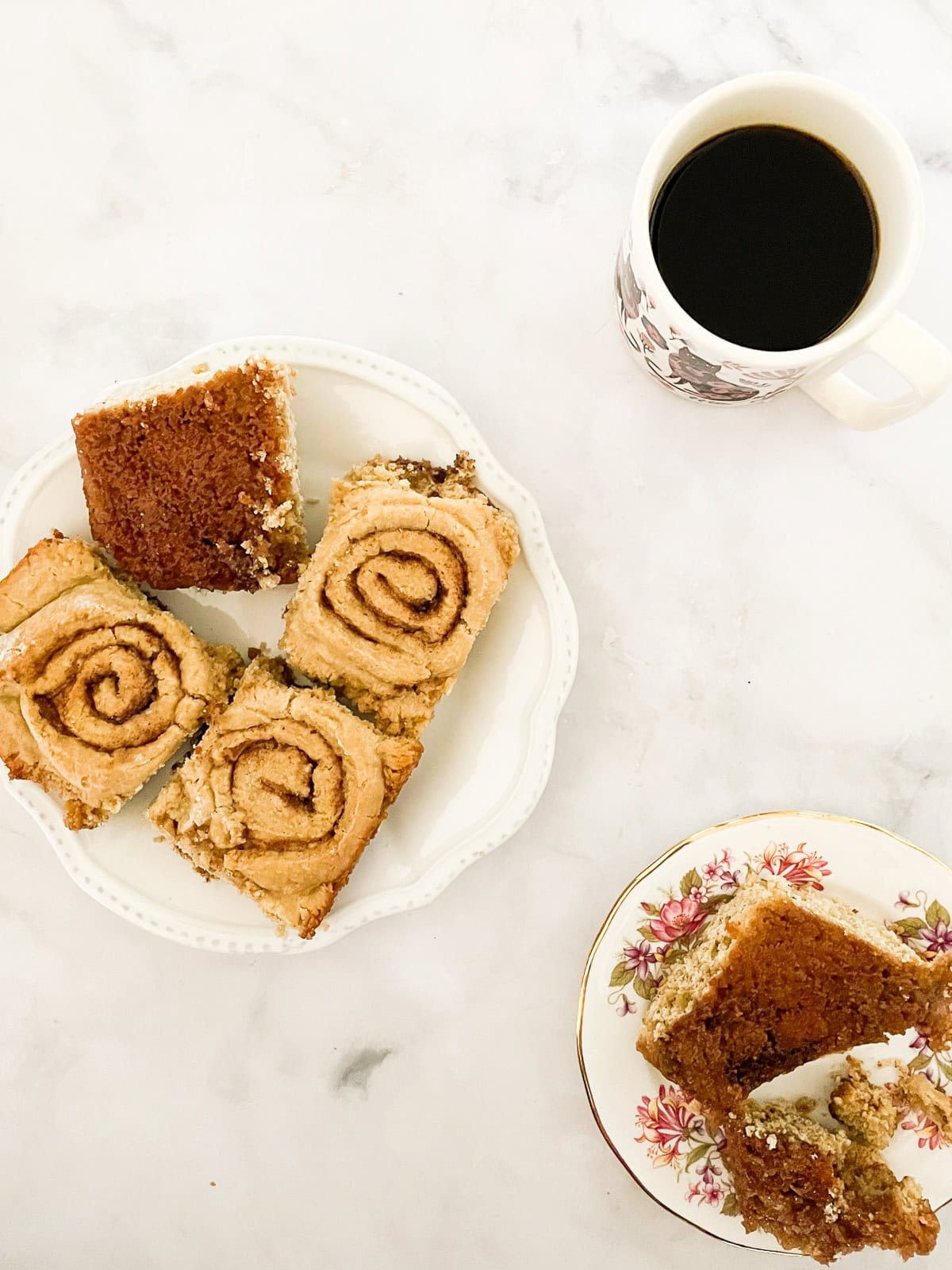 A plate of gluten-free cinnamon rolls with a cup of coffee.