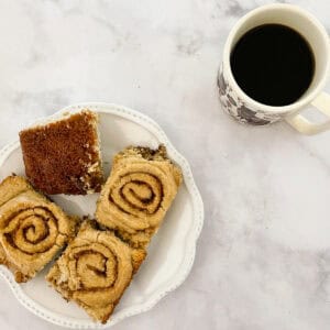 A plate of gluten-free cinnamon rolls with a cup of coffee.