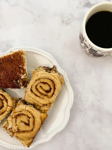 A plate of gluten-free cinnamon rolls with a cup of coffee.