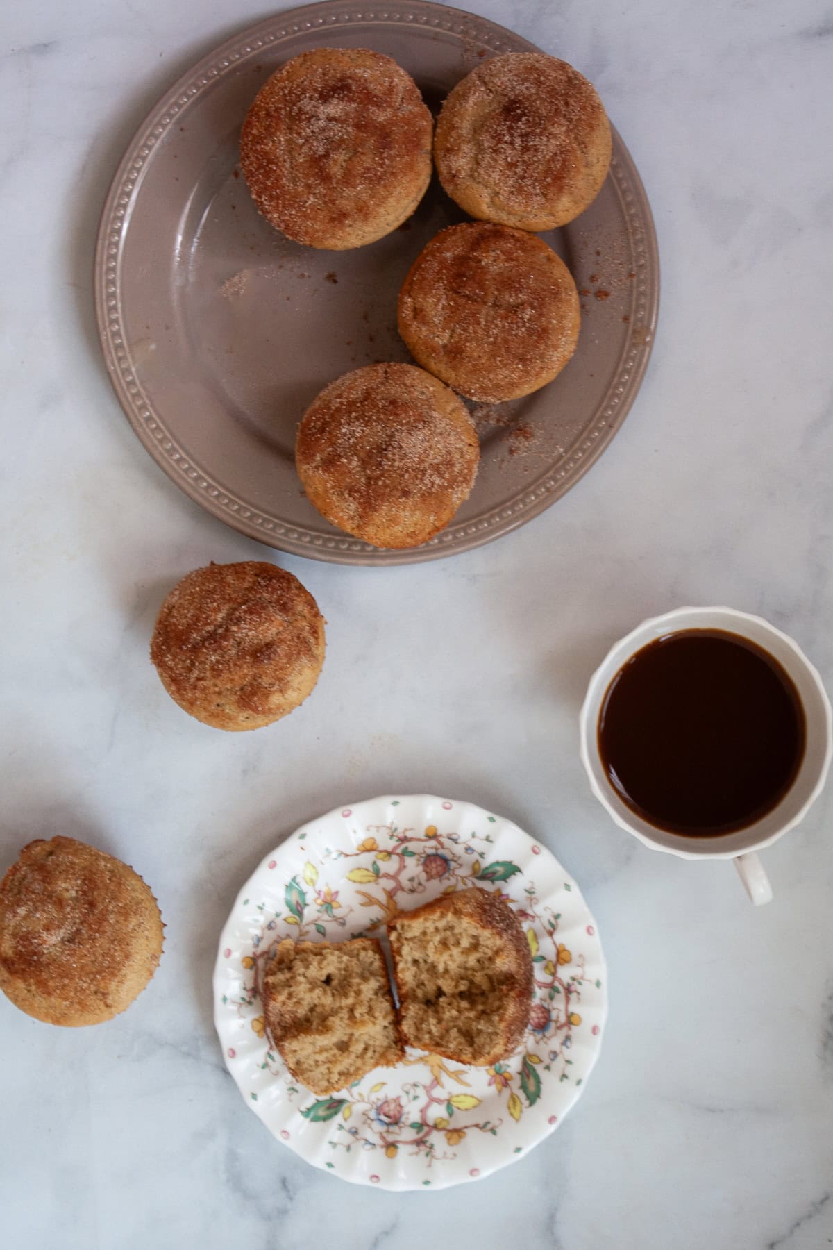 A muffin cut in half on a plate and more muffins.