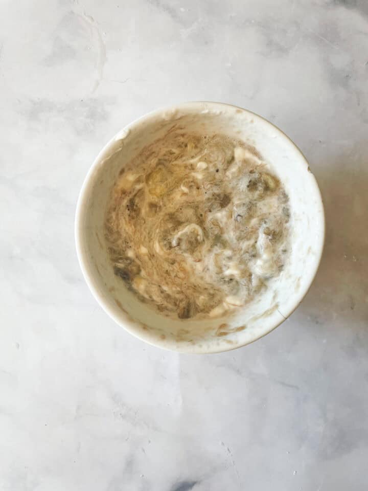 Yogurt and bananas mixed in a bowl.