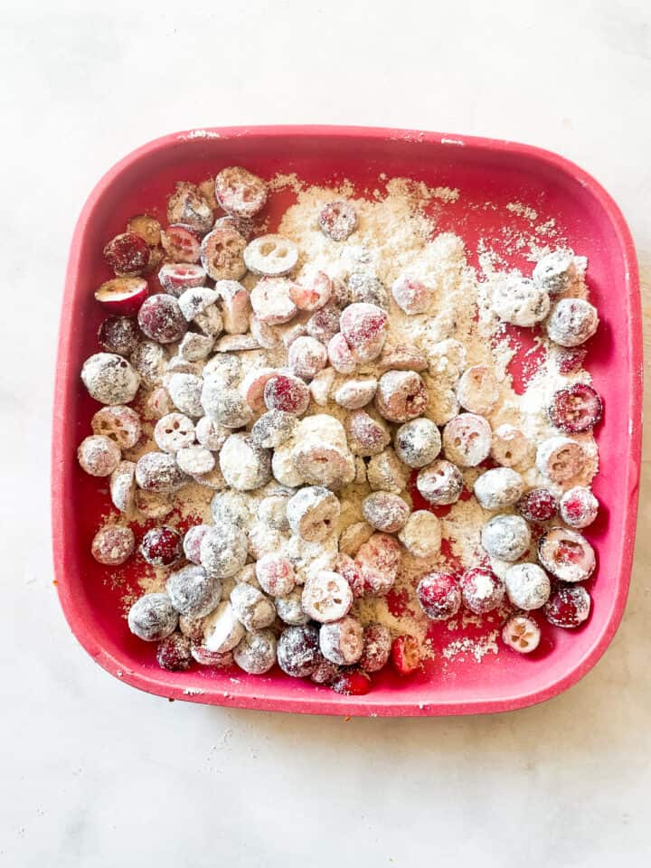 Fresh cranberries tossed with flour on a plate.