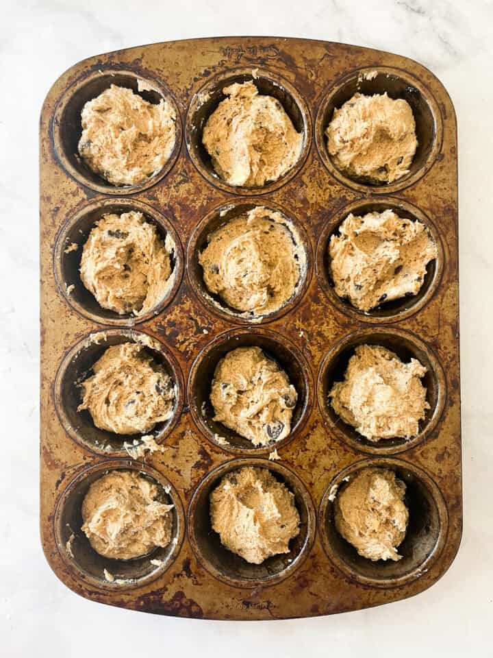 Gluten free banana bread muffins batter in a muffin tin.