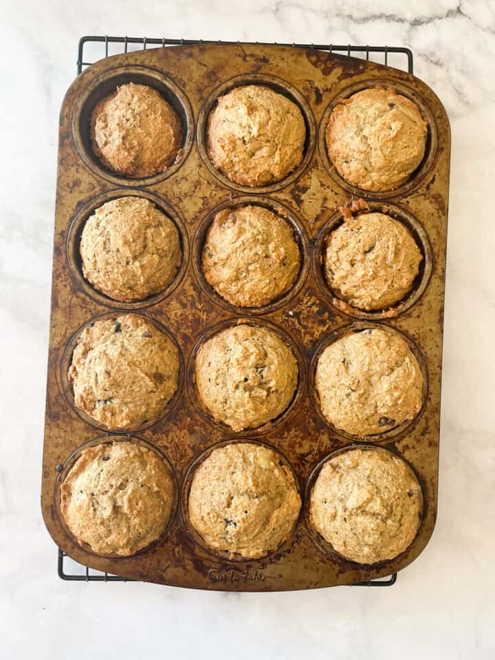 A muffin tin with baked gluten free banana bread muffins.