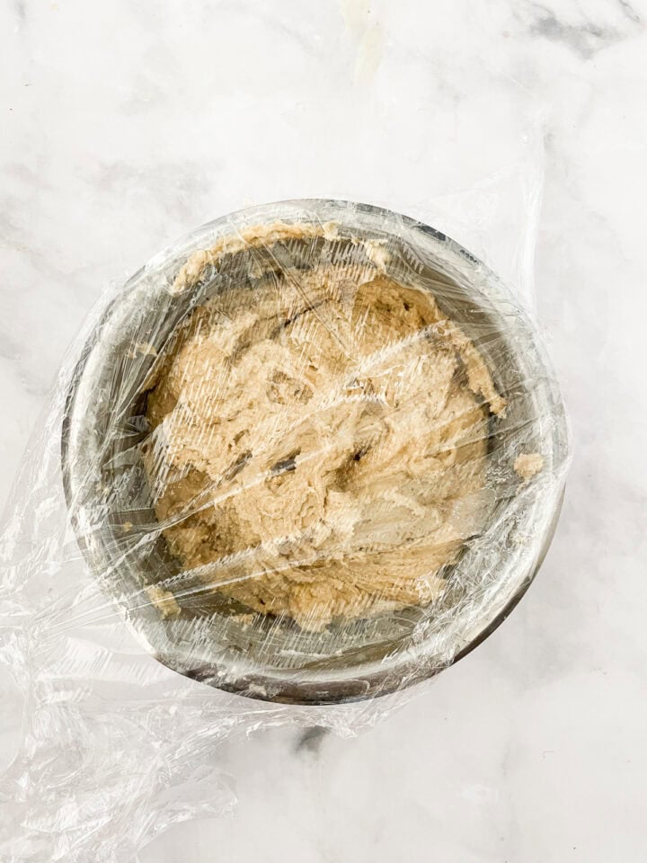 Cinnamon roll dough covered in a bowl.