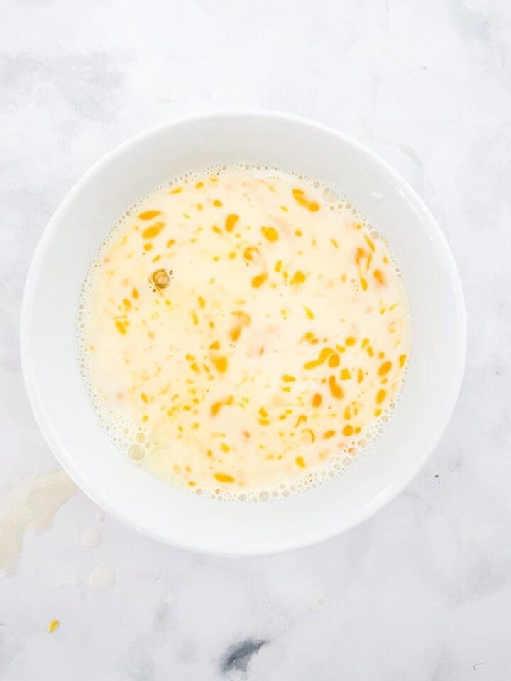 Egg, milk and butter mixed together in a bowl.