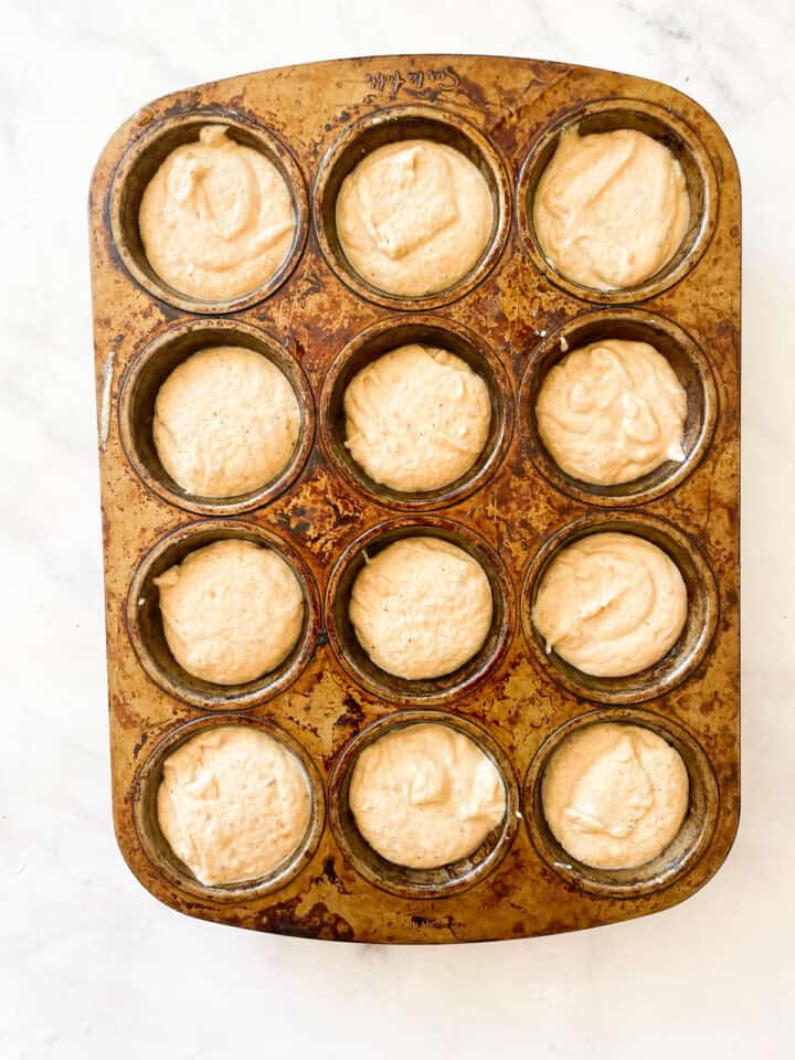 Muffin batter in a muffin tin.