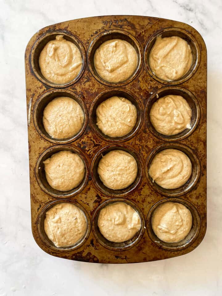 Donut muffin batter in a muffin tin.