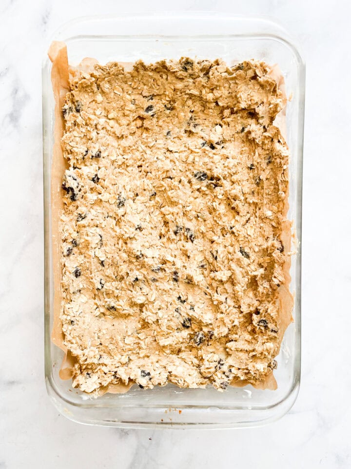 Oatmeal raisin bars dough in a pan.