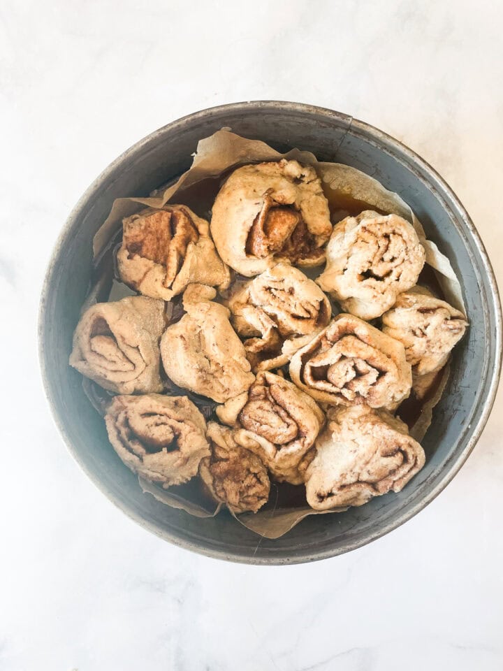 Oat flour cinnamon rolls added to a pan.