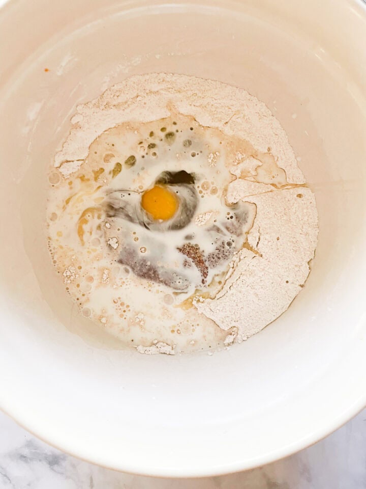 Wet ingredients are added to dough mix in a bowl.