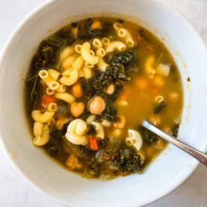 A bowl of vegetarian minestrone with a spoon.