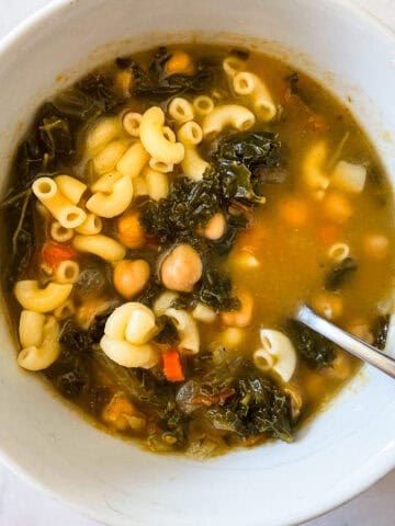 A bowl of vegetarian minestrone with a spoon.