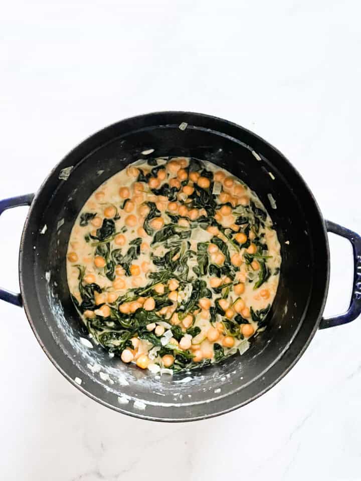 Coconut milk and wilted spinach in a french oven.