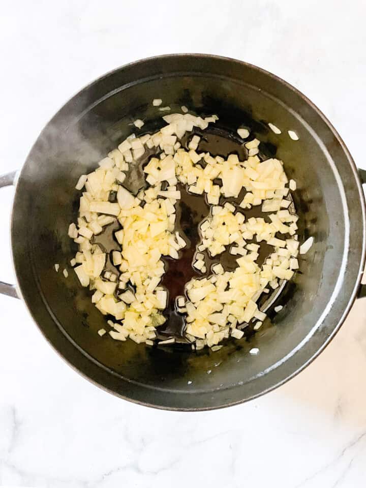 Onion cooks in olive oil in a french oven.