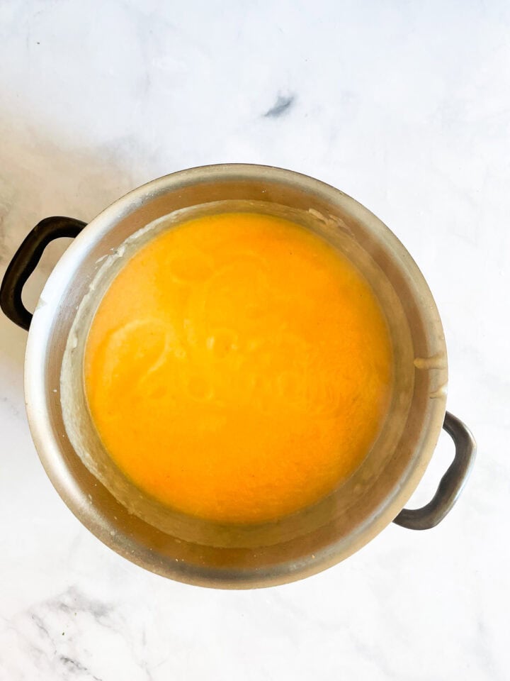 Pureed carrot cauliflower soup in a pot.