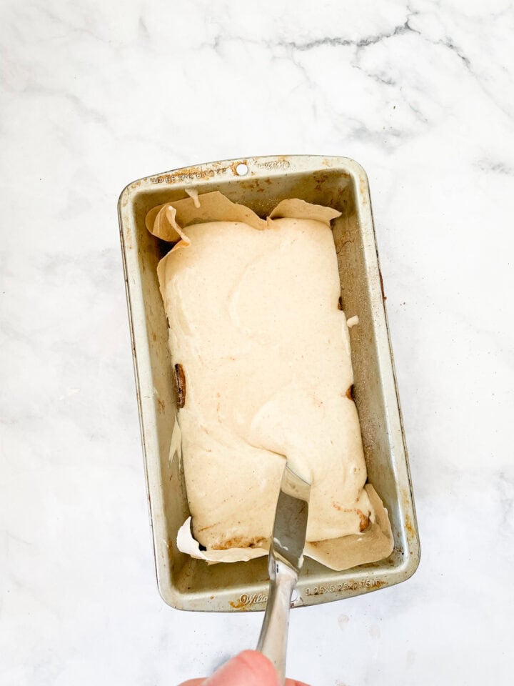 A knife swirls cinnamon in a batter.