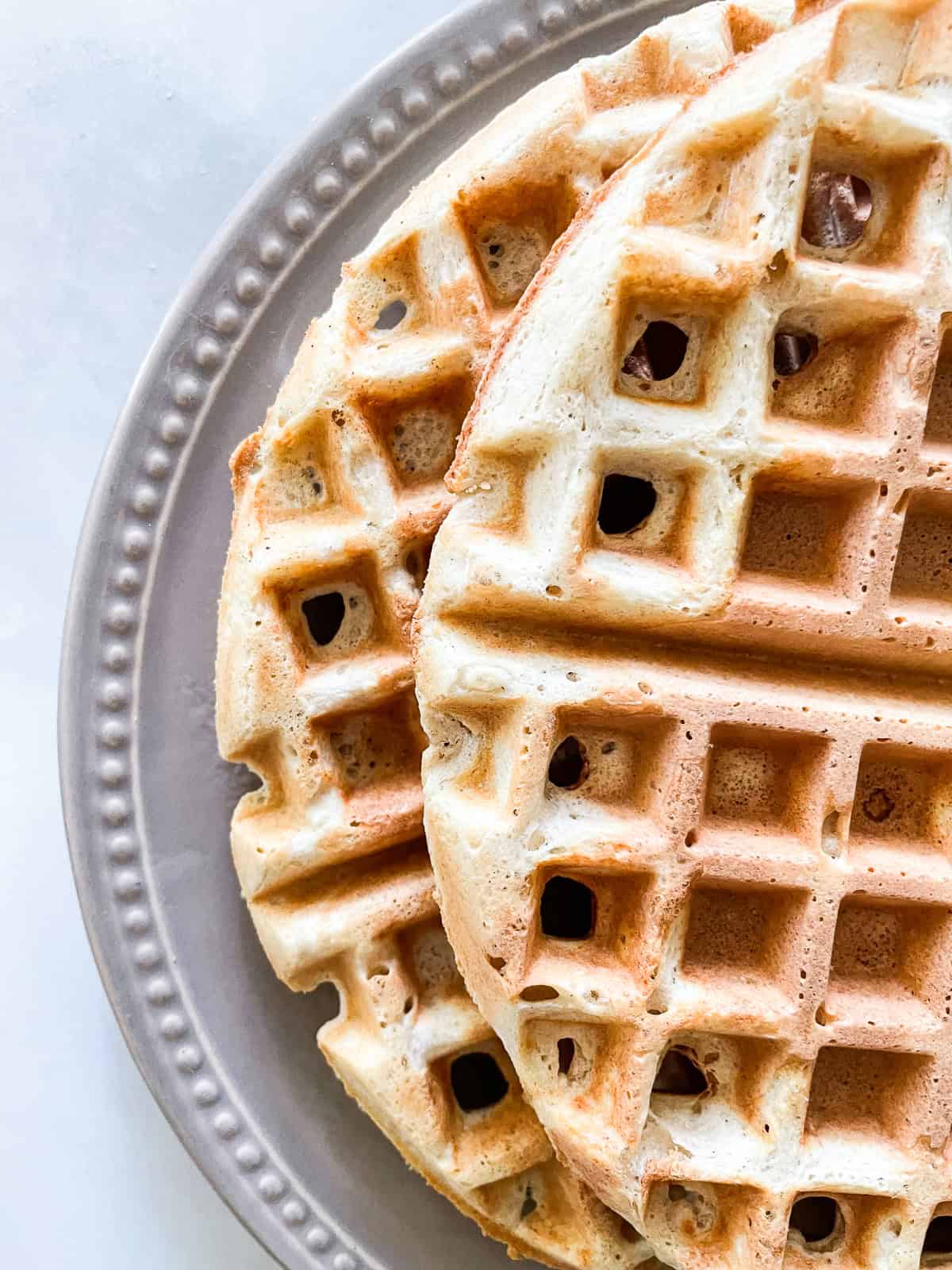 Two waffles on a plate, half are shown.