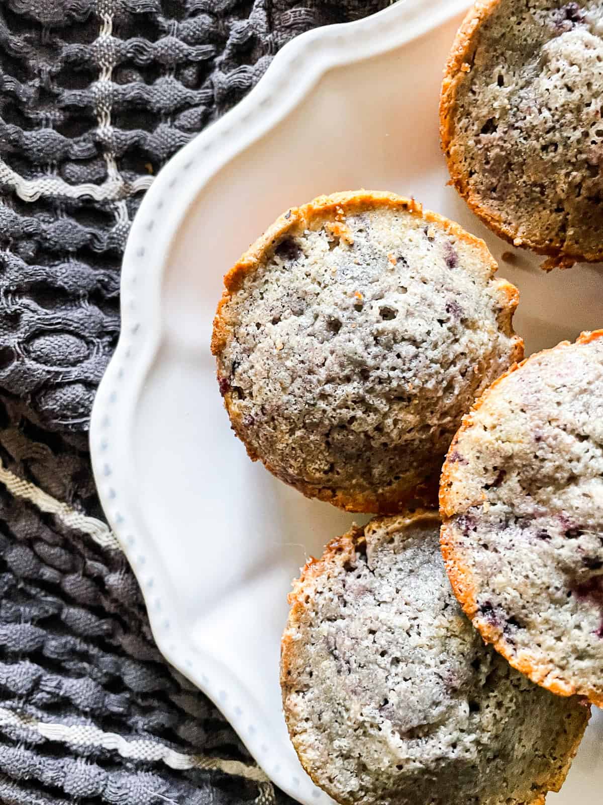 Gluten-free blackberry muffins on a plate on a towel.