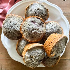 A plate of gluten-free blackberry muffins on a table.