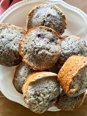 A plate of gluten-free blackberry muffins on a table.