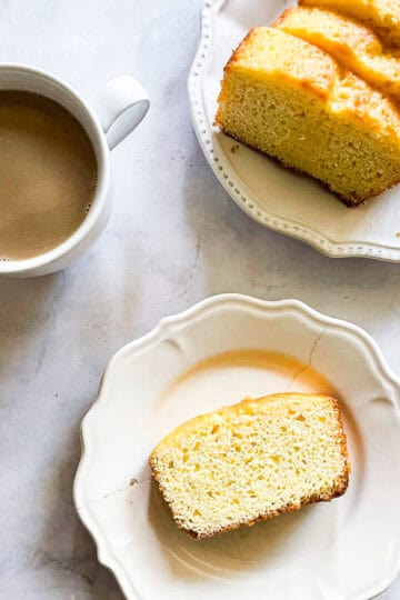 A cup of coffee and plates with slices of yogurt lemon cake.