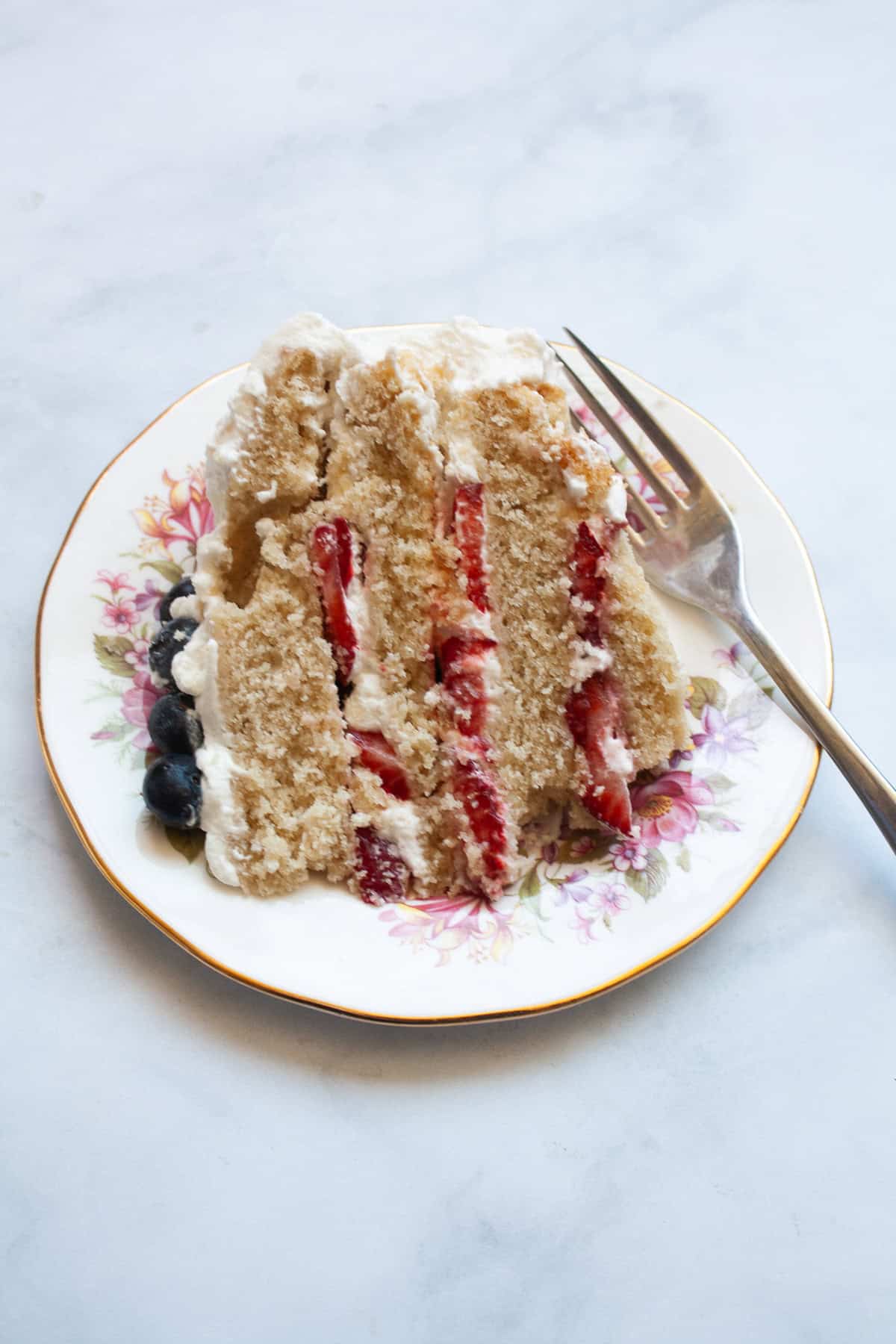 A slice of gluten free berries and cream cake.