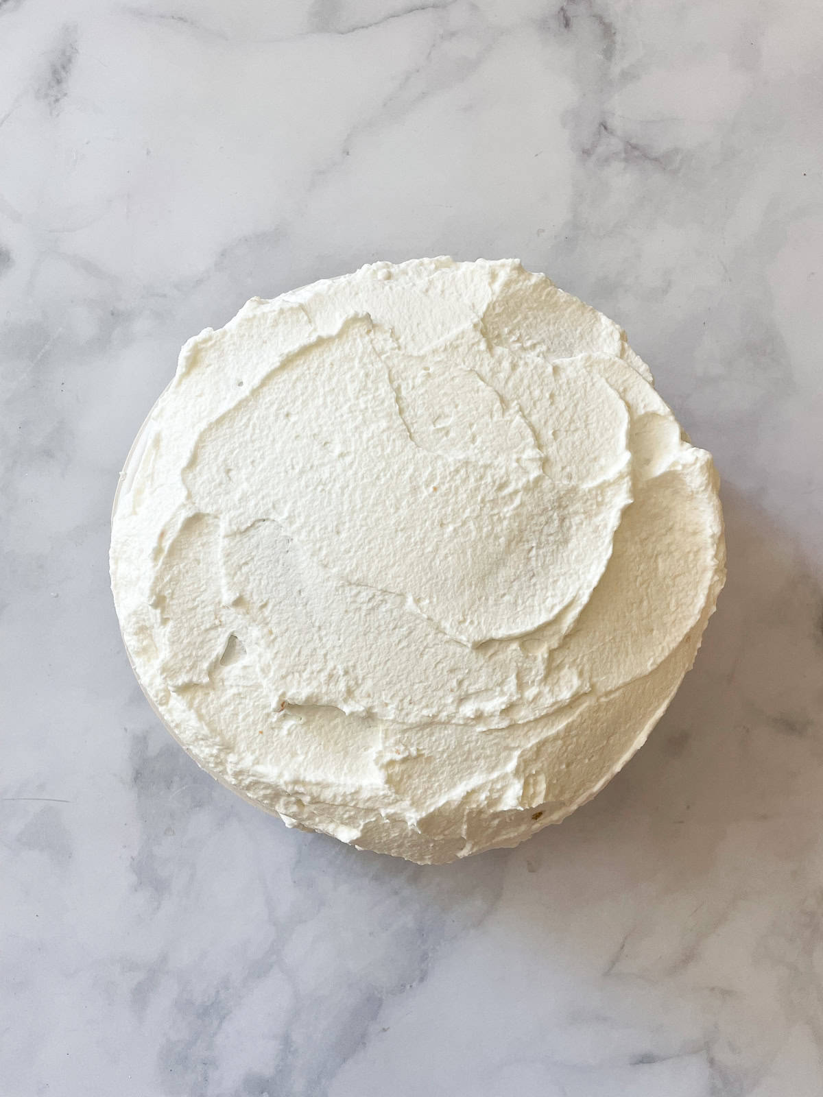 A gluten free berries and cream cake is layered with sweet whipped cream, sliced strawberries, and juicy blueberries. A berries and cream cake is frosted with whipped cream.